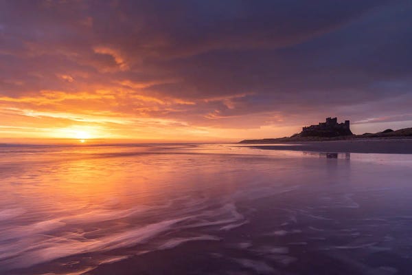 Beach Sunrises & Sunsets: Approaching Bebbanburgh by Adam Burton