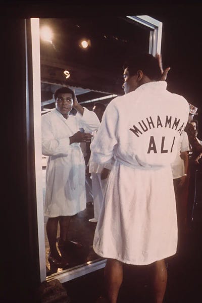 A Robed Muhammad Ali Admiring Himself In The Mirror