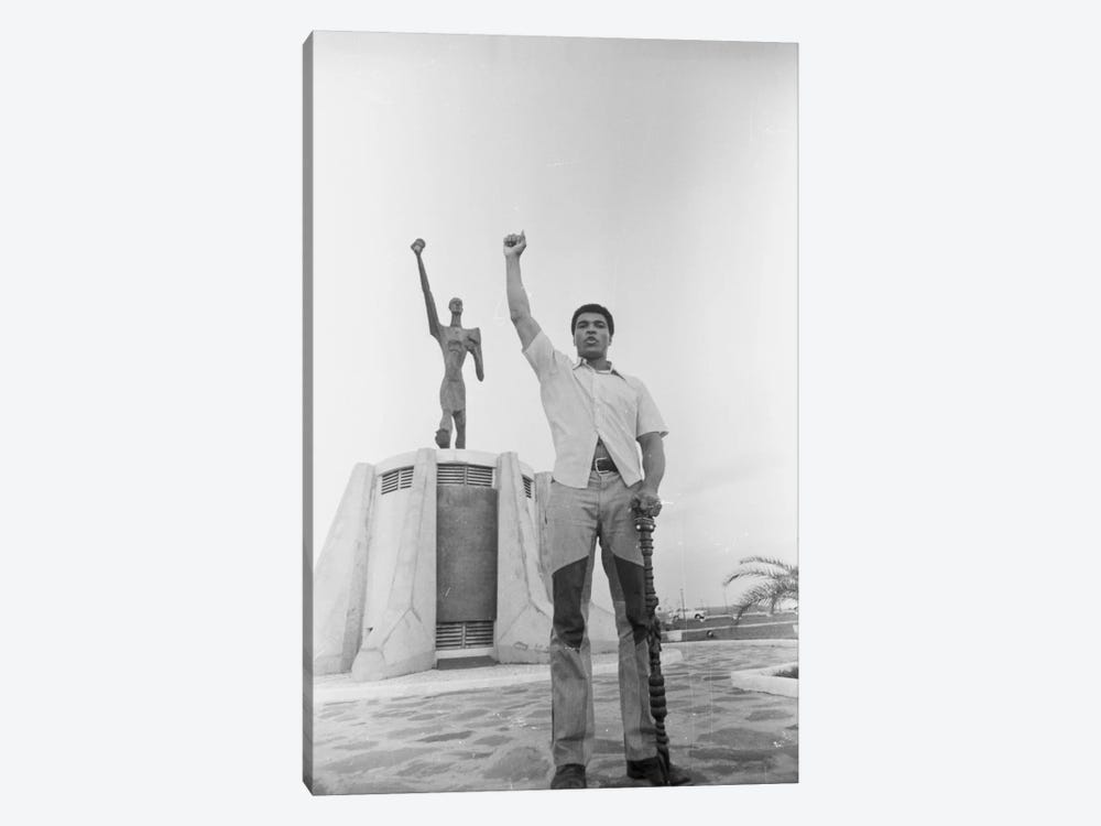 Muhammad Ali Posing In Front Of The Le Militant Statue, Kinshasa, Zaire by Muhammad Ali Enterprises 1-piece Canvas Artwork