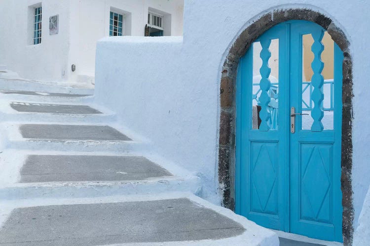 Greece, Santorini. Blue door livens up a quiet alley of white-washed homes in Pyrgos.