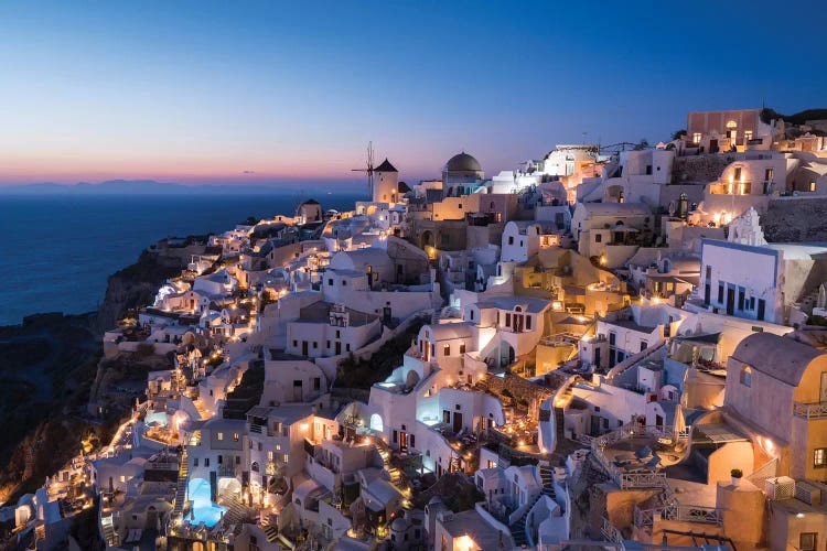 Greece, Santorini. The Village Of Oia Glows In The Post-Sunset Light As The Town'S Lights Add Magic To This Iconic Scene.