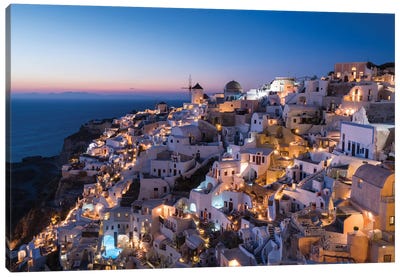 Greece, Santorini. The Village Of Oia Glows In The Post-Sunset Light As The Town'S Lights Add Magic To This Iconic Scene. Canvas Art Print