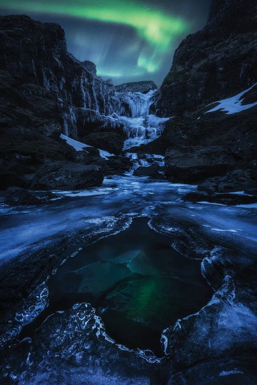 Northern Light Dancing Above A Frozen Waterfall In Iceland