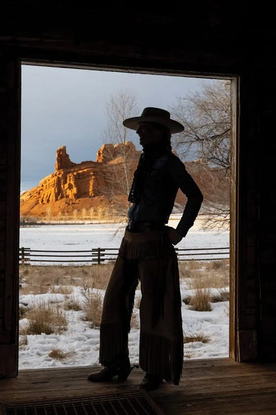 USA, Shell, Wyoming Hideout Ranch With Cowgirl Silhouetted In Doorway Of Log Cabin by Darrell Gulin art print