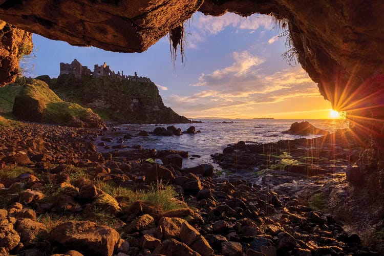 Cave Frames Sunset At Dunluce Castle, Causeway Coast, County Antrim, Northern Ireland by Gareth McCormack wall art