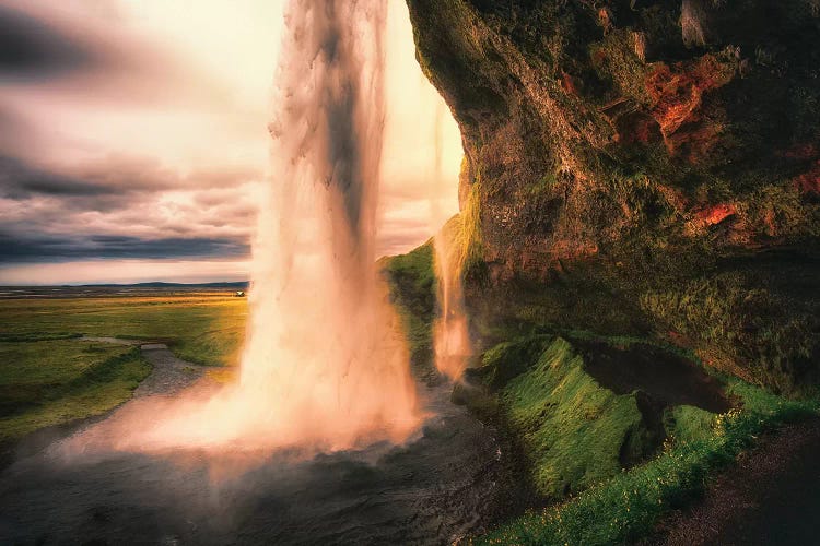 View of the Seljalandsfoss Waterfall Behind from a Cave at Sunset, Iceland