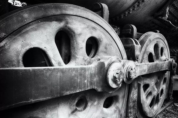 George Oze: Close Up View Of Wheels Of A Steel Locomotive by George Oze