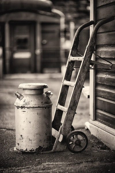 George Oze: Old Milk Can With A Hand Barrows At A Train Station by George Oze