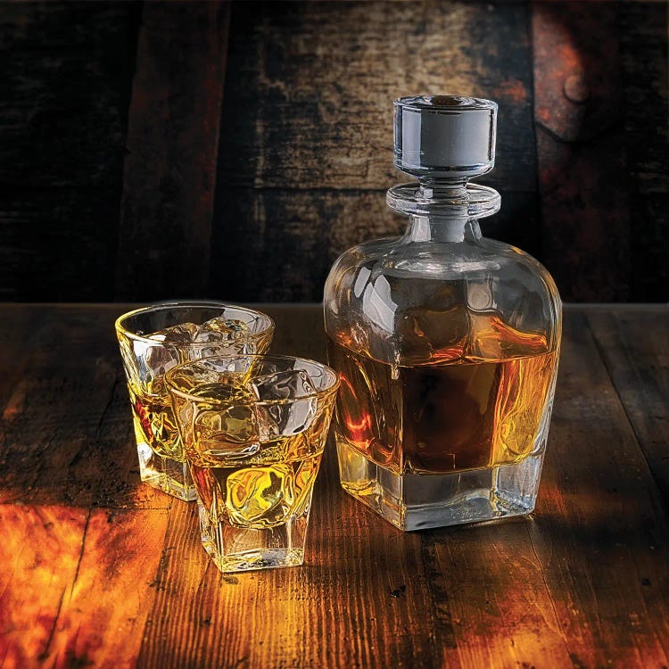 A Whiskey Bottle And Two Glasses On The Rocks On A Wooden Table