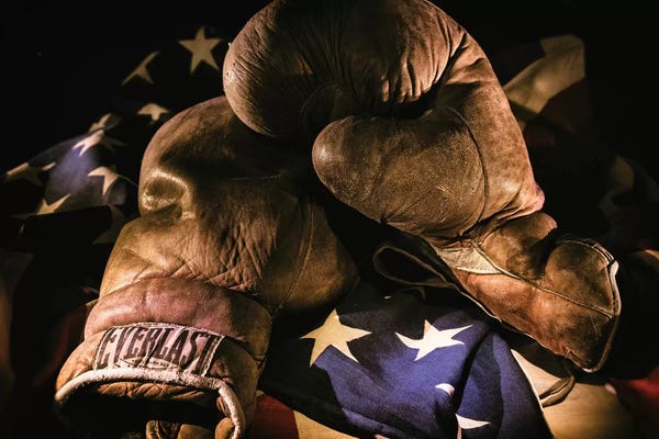 Inspirational Office: Pair of vintage boxing gloves laying on a flag carefully painted with light by Sheila Haddad