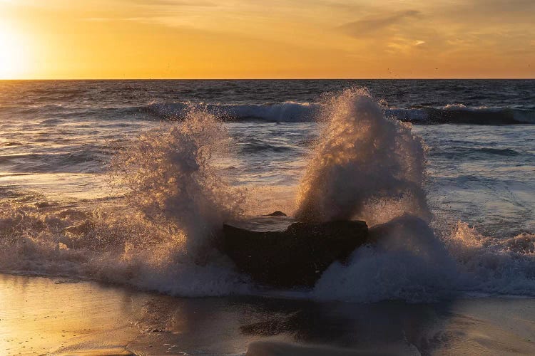 Golden sunset light coming through the white water crashing off a rock