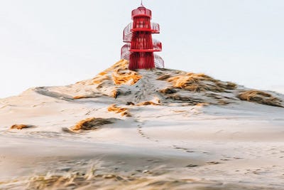 Red Lighthouse Tower On The Sandy Shore Of The Ocean by Ievgeniia Bidiuk framed wall art