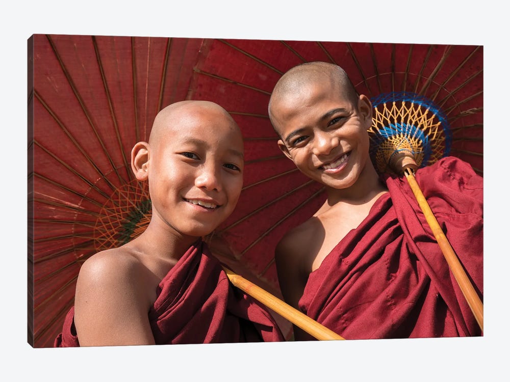 Two Young Buddhist Monks Smiling And Holding Red Umbrellas, Myanmar by Jan Becke 1-piece Canvas Wall Art