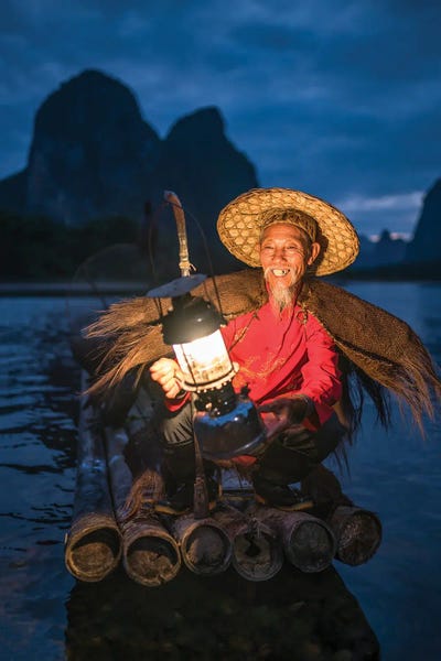 Chinese Culture: Chinese cormorant fisherman at night on the Li river, Guangxi, Yangshuo, China by Jan Becke