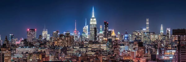 New York City Skylines: Panoramic View Of The Midtown Manhattan Skyline With Empire State Building At Night by Jan Becke