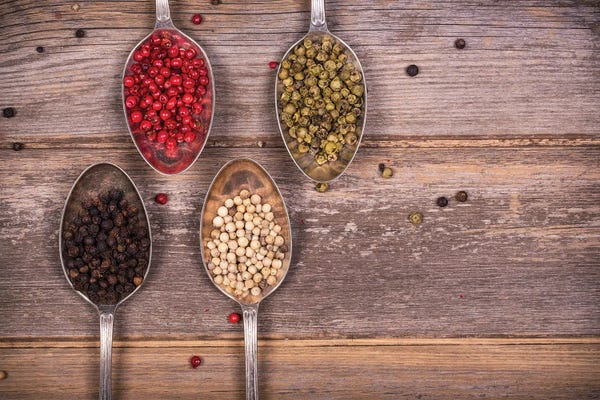 Assorted Peppercorns On Silver Spoons