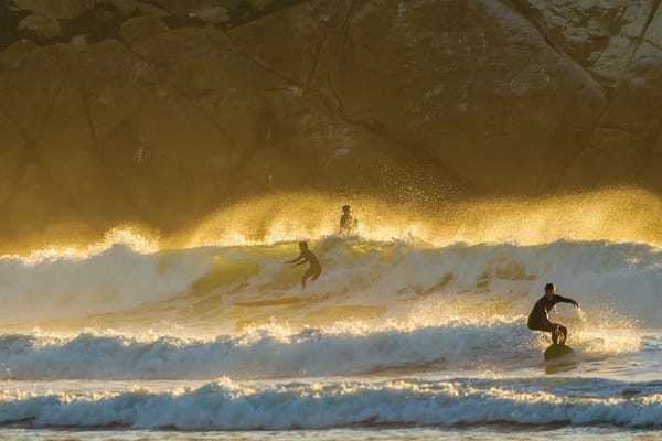 Sky: USA, California, San Luis Obispo County. Surfers at sunset. by Jaynes Gallery