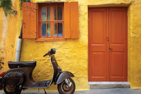 Greece, Rhodes. Vespa motorbike and colorful house exterior.