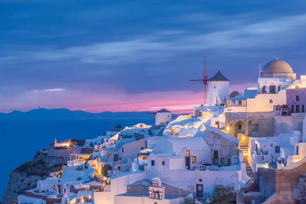 Greece, Oia. Greek Orthodox church and village at sunset.