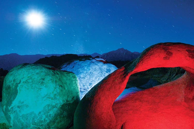 USA, California, Alabama Hills. Mobius Arch and rocks lit with colors on moonlit night.