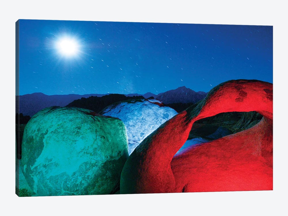 USA, California, Alabama Hills. Mobius Arch and rocks lit with colors on moonlit night. by Jaynes Gallery 1-piece Canvas Art Print