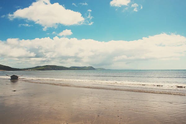 England: A Row Boat Abandoned On The Beach At Lyme Regis In England by Laura Evans