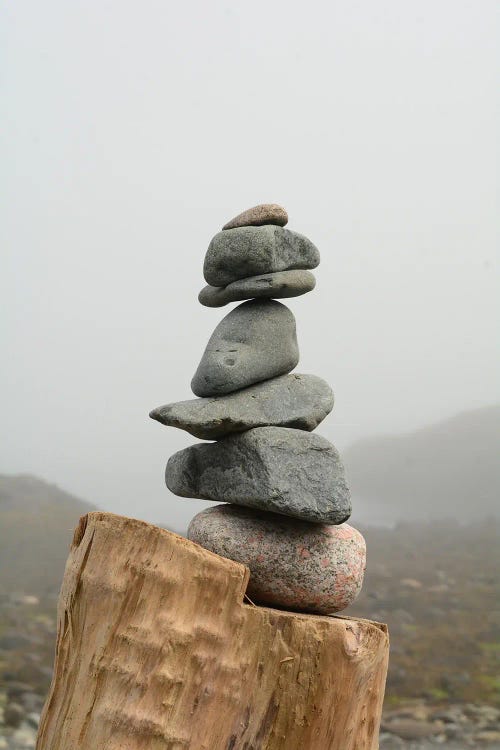 Rock Cairn On Foggy Beach