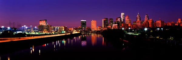 Blue: Buildings lit up at the waterfront, Philadelphia, Schuylkill River, Pennsylvania, USA by Panoramic Images