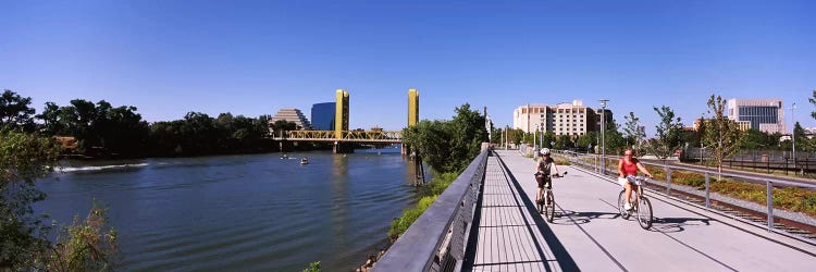 Bicyclists along the Sacramento River with Tower Bridge in background, Sacramento, Sacramento County, California, USA