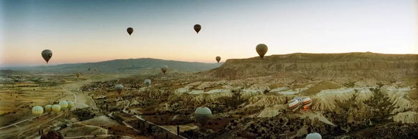 Extreme Sports: Hot air balloons over landscape at sunrise, Cappadocia, Central Anatolia Region, Turkey by Panoramic Images