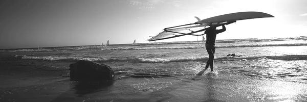 Extreme Sports: Man carrying a surfboard over his head on the beach, Santa Cruz, California, USA by Panoramic Images