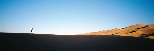 Colorado: Low angle view of a woman running in the desert 2, Great Sand Dunes National Monument, Colorado, USA by Panoramic Images