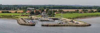 Boats Moored At Harbor With Village In The Background, Limfjord, Jutland, Denmark by Panoramic Images canvas print