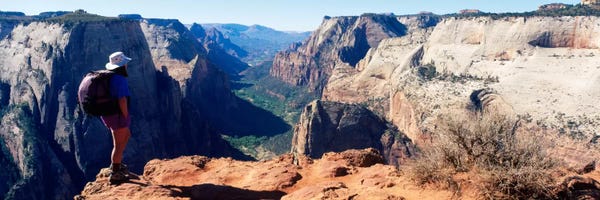 Zion National Park: Female hiker standing near a canyonZion National Park, Washington County, Utah, USA by Panoramic Images