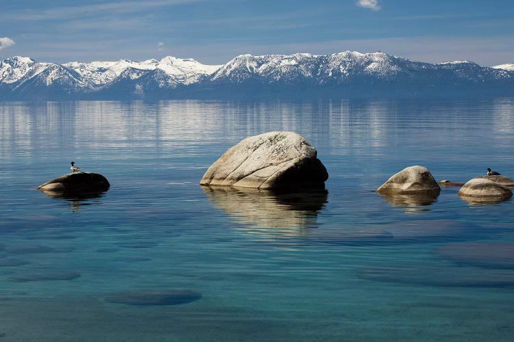 Rocks in a lake with mountain range in the background, Lake Tahoe, California, USA