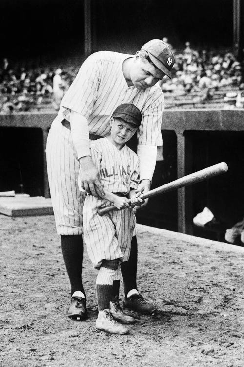 Babe Ruth Coaching Young Boy How To Swing Bat On Baseball Field