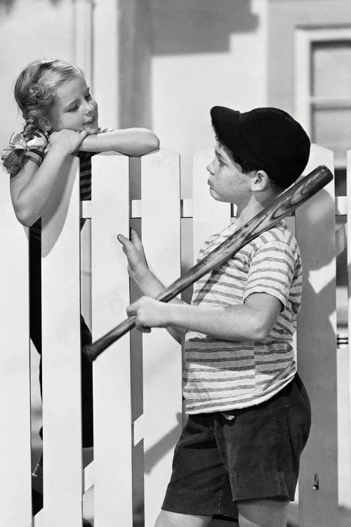 1950s Boy Talking To Girl Over White Picket Fence