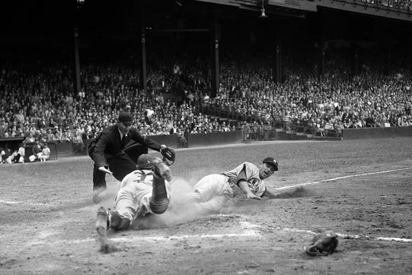 Athletes & Coaches: 1950s Professional Major League Baseball Game Runner Sliding Into Home Base As Umpire Signals Safe by Panoramic Images