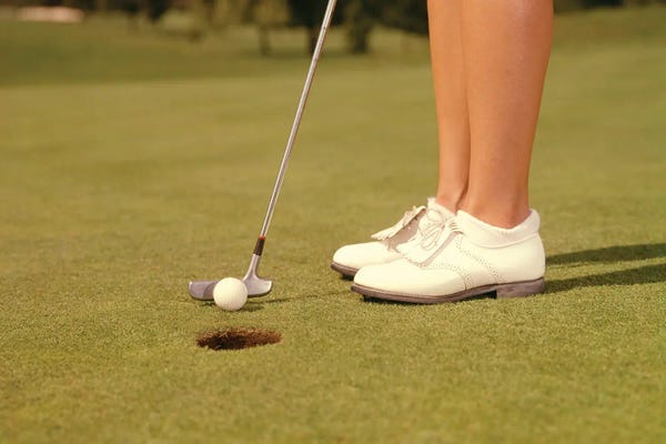 Golf Courses: 1960s Close-Up Of Golfer About To Stroke Ball Into Hole On The Green by Panoramic Images