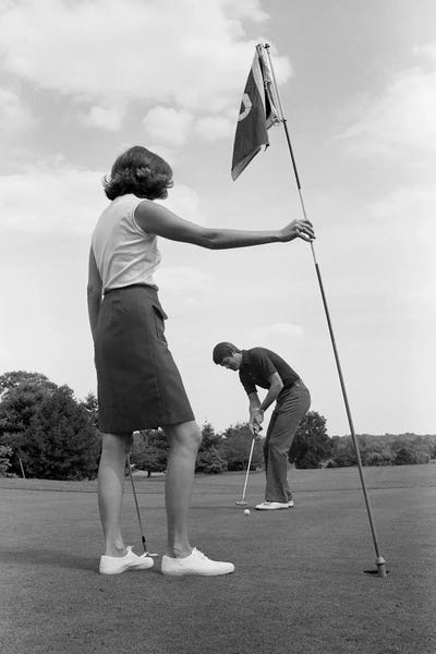 1970s Couple Playing Golf Man Putting Woman Holding Flag by Panoramic Images framed canvas print