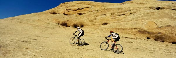 Moab: Side profile of two men mountain bilking on rocks, Slickrock Trail, Moab, Utah, USA by Panoramic Images