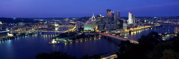 Buildings along a river lit up at dusk, Monongahela River, Pittsburgh, Allegheny County, Pennsylvania, USA