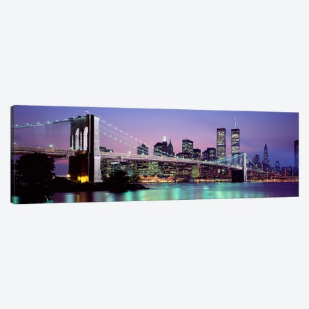 An Illuminated Brooklyn Bridge With Lower Manhattan's Financial District Skyline In The Background, New York City, New York  Canvas Print #PIM2259} by Panoramic Images Canvas Artwork