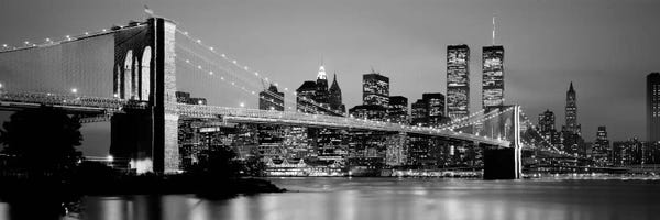 Panoramic Images: Illuminated Brooklyn Bridge With Lower Manhattan's Financial District Skyline In The Background In B&W, New York City, New York  by Panoramic Images