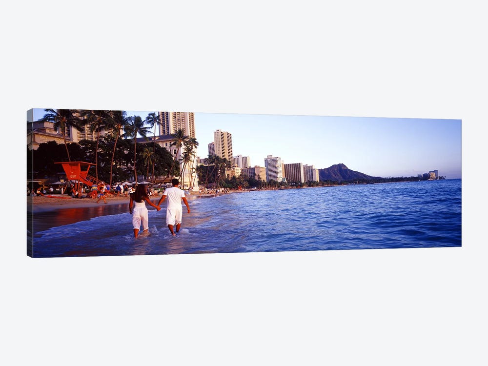 Rear view of a couple wading on the beach, Waikiki Beach, Honolulu, Oahu, Hawaii, USA by Panoramic Images 1-piece Canvas Print