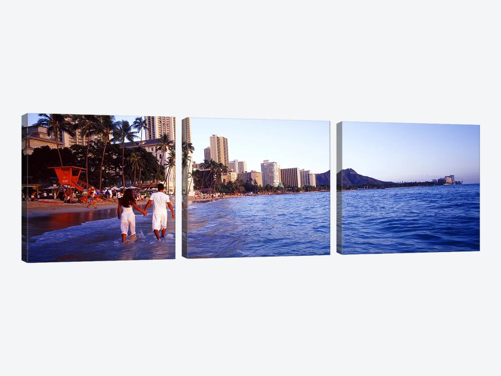 Rear view of a couple wading on the beach, Waikiki Beach, Honolulu, Oahu, Hawaii, USA by Panoramic Images 3-piece Art Print