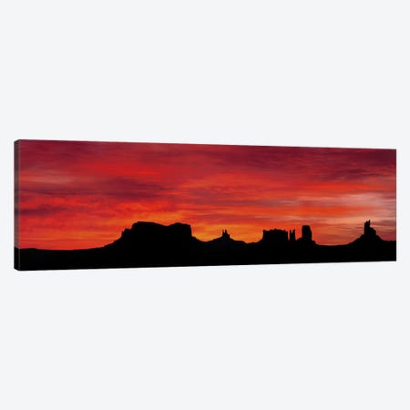 Silhouette Of Monument Valley's Buttes Across A Deep Orange Sunset Canvas Print #PIM4566} by Panoramic Images Canvas Print
