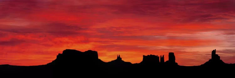 Silhouette Of Monument Valley's Buttes Across A Deep Orange Sunset