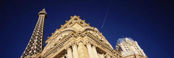 Las Vegas: Low angle view of a building in front of a replica of the Eiffel Tower, Paris Hotel, Las Vegas, Nevada, USA by Panoramic Images