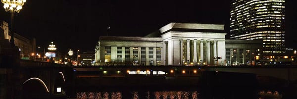Pennsylvania: Buildings lit up at night at a railroad station, 30th Street Station, Schuylkill River, Philadelphia, Pennsylvania, USA by Panoramic Images